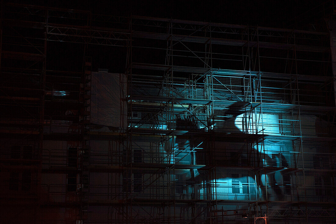Illuminated horse and rider displayed on a wall with scaffolding, Berlin, Germany