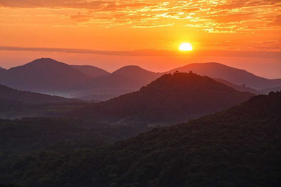 The sun rising straight behind the castle ruins of Lindelbrunn, Palatinate Forest, Rhineland-Palatinate, Germany