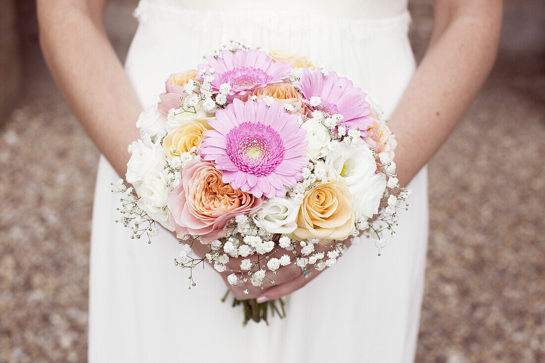 Bride holding bouquet of flowers, cropped