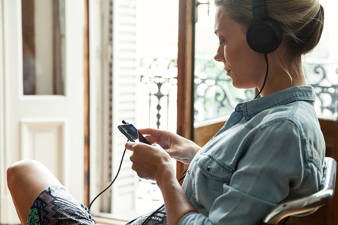 Woman listening to music playing on smartphone