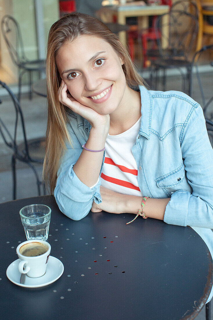 Young woman relaxing at cafe, portrait