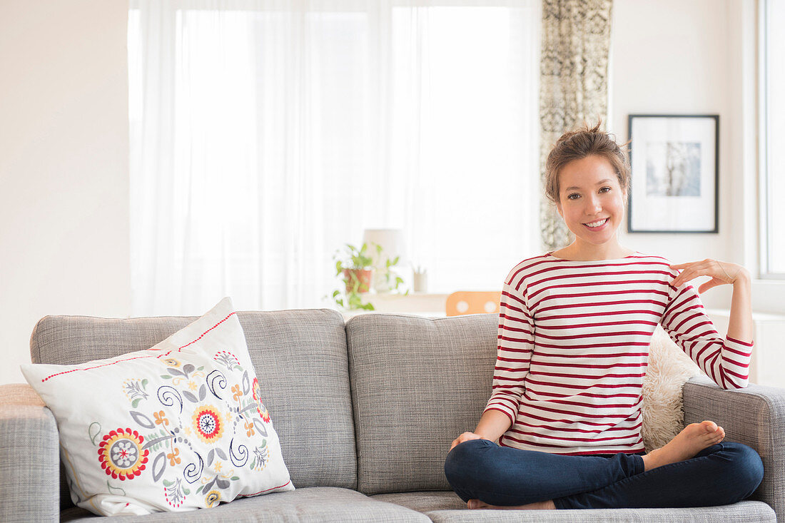 Mixed race woman sitting on sofa