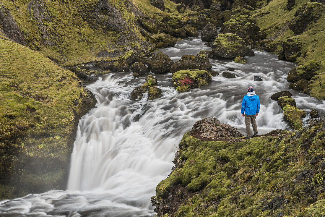 Tourist at a waterfall on the hiking trail above Skogafoss Waterfall, Skogar, South Region Sudurland, Iceland, Polar Regions