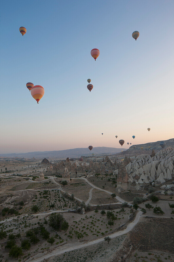Hot air balloons flying over rocky landscape