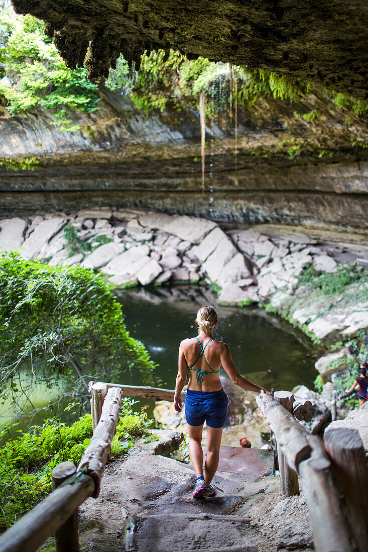 A young woman enjoys the Hamilton Pool near Wimberley, Texas on a hot day.