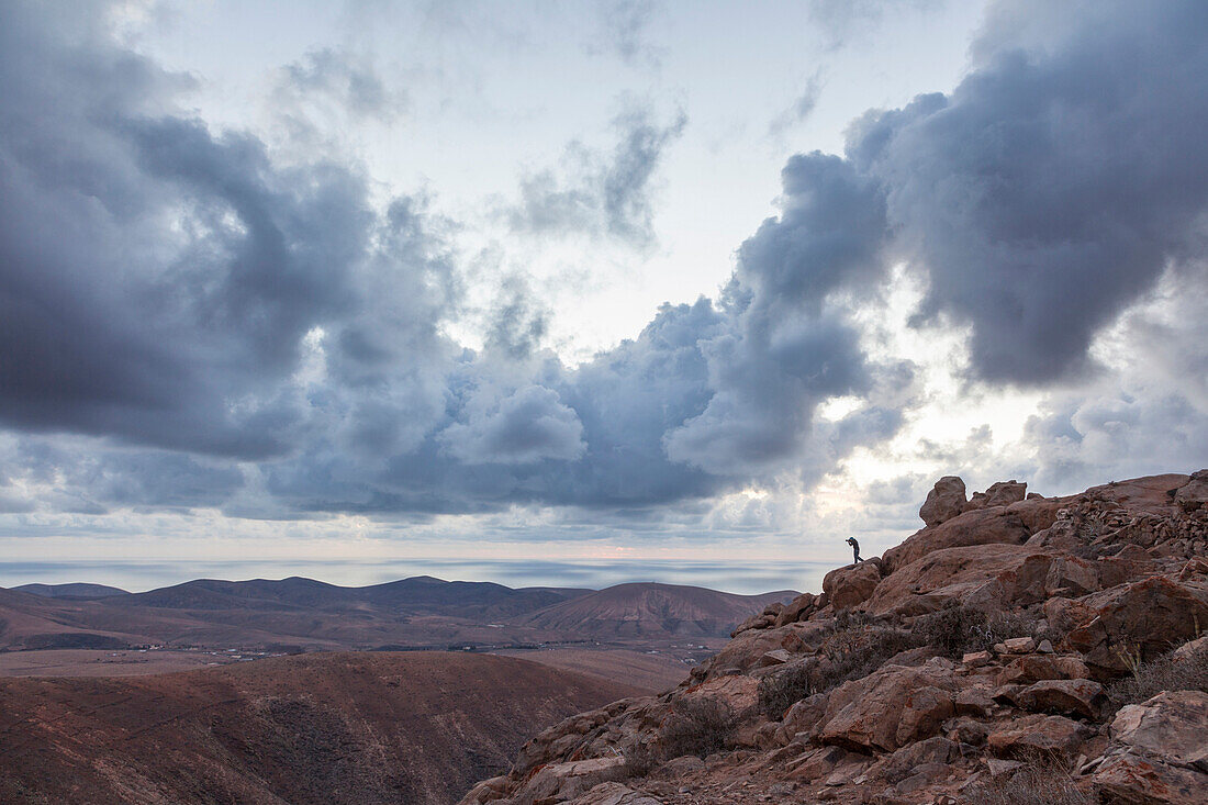 Photographer's silhouette in action in a dramatic landscape