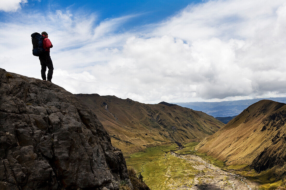 A backpacker looks over the valley at the base of El Altar, Ecuador's 5th tallest volcano.