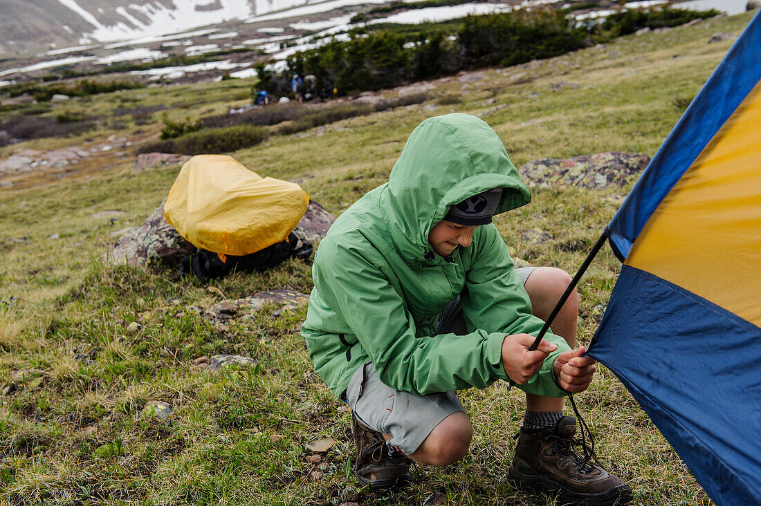 A boy hurries to pitch a tent before a rainstorm arrives, at a camp in an alpine meadow by Little Superior Lake, on the 3rd night of Troop 693's six day backpack trip through the High Uintas Wilderness Area, Uintas Range, Utah