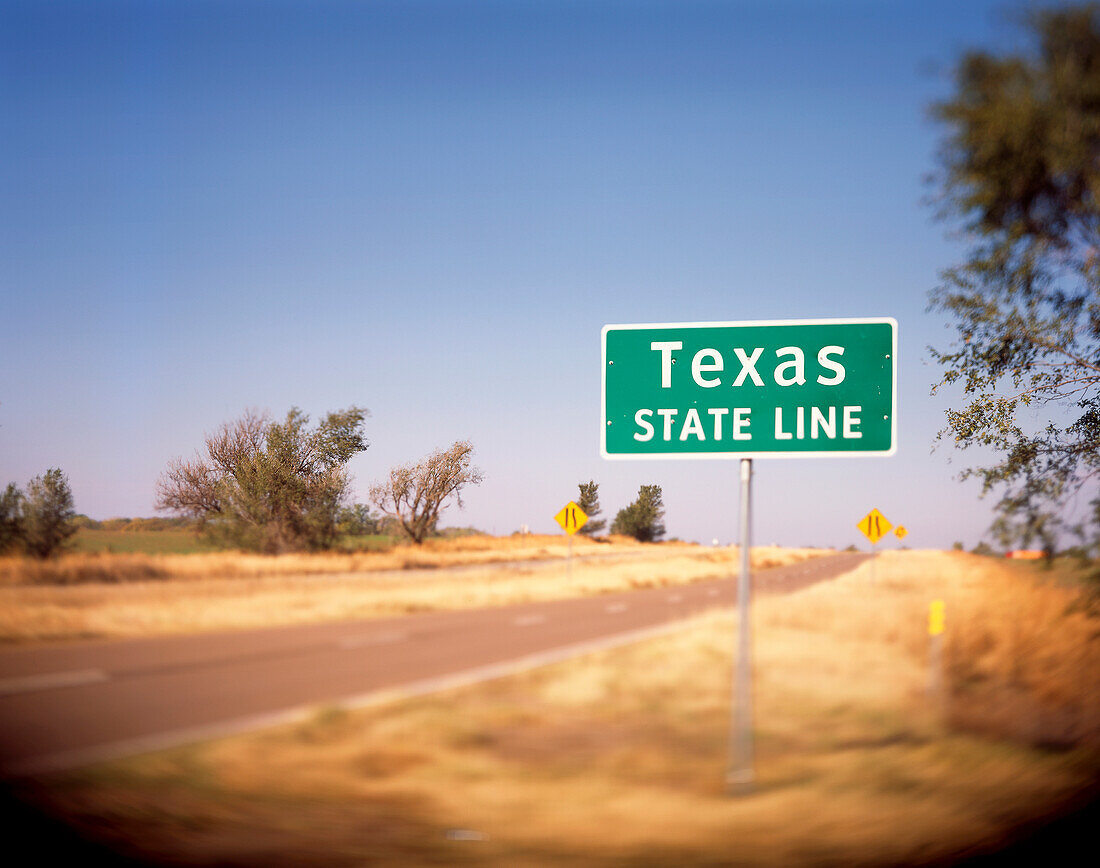 A Texas State Line sign on a back road in Oklahoma lets the driver know that they are about to enter the Great State.