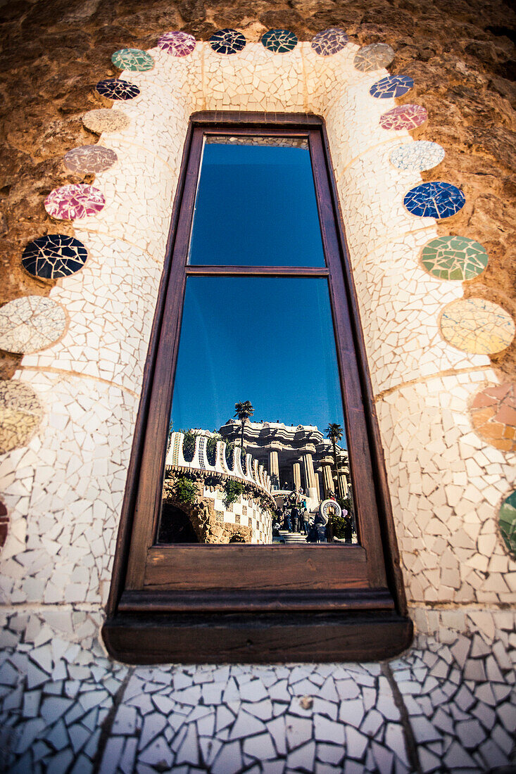 Reflections of a building in a window, both of which were designed by Gaudi.