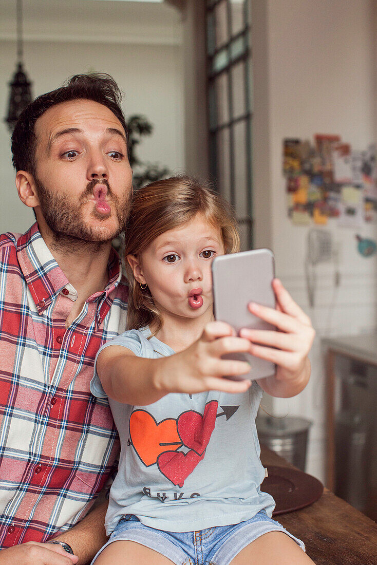 Father posing for selfie with daughter
