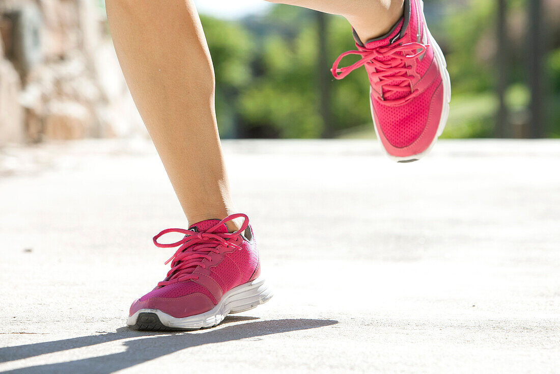 Woman jogging in sports shoes, cropped