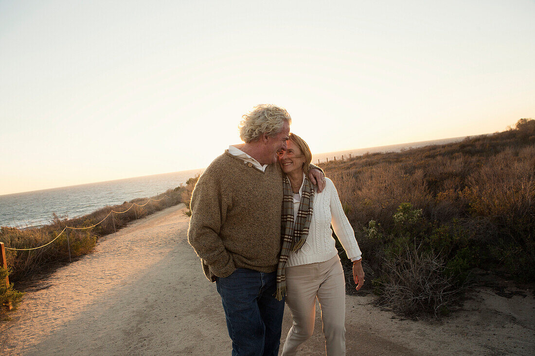 Older Caucasian couple walking on dirt path