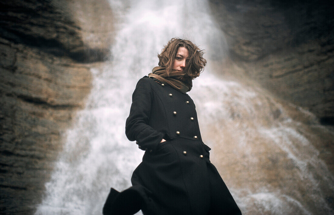 Caucasian woman standing under waterfall