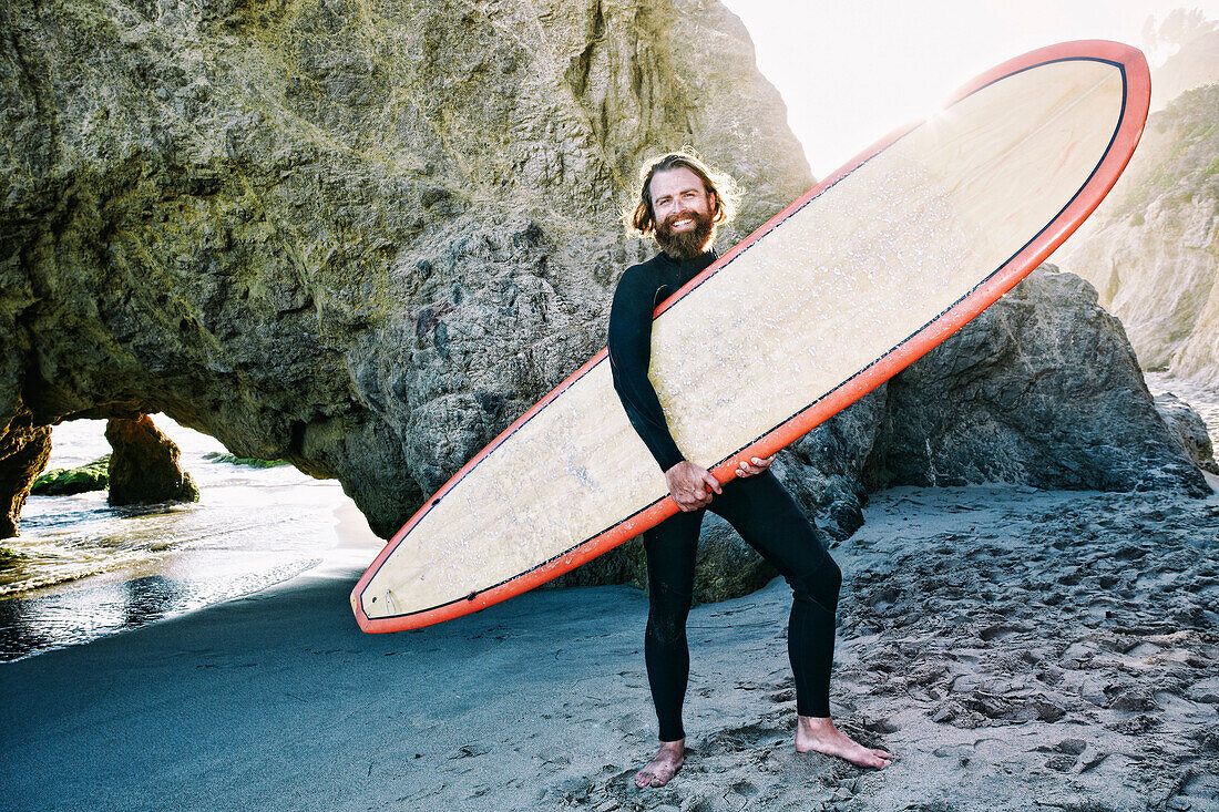 Caucasian man holding surfboard at beach