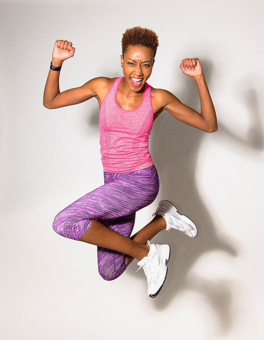 Mixed race athlete jumping for joy