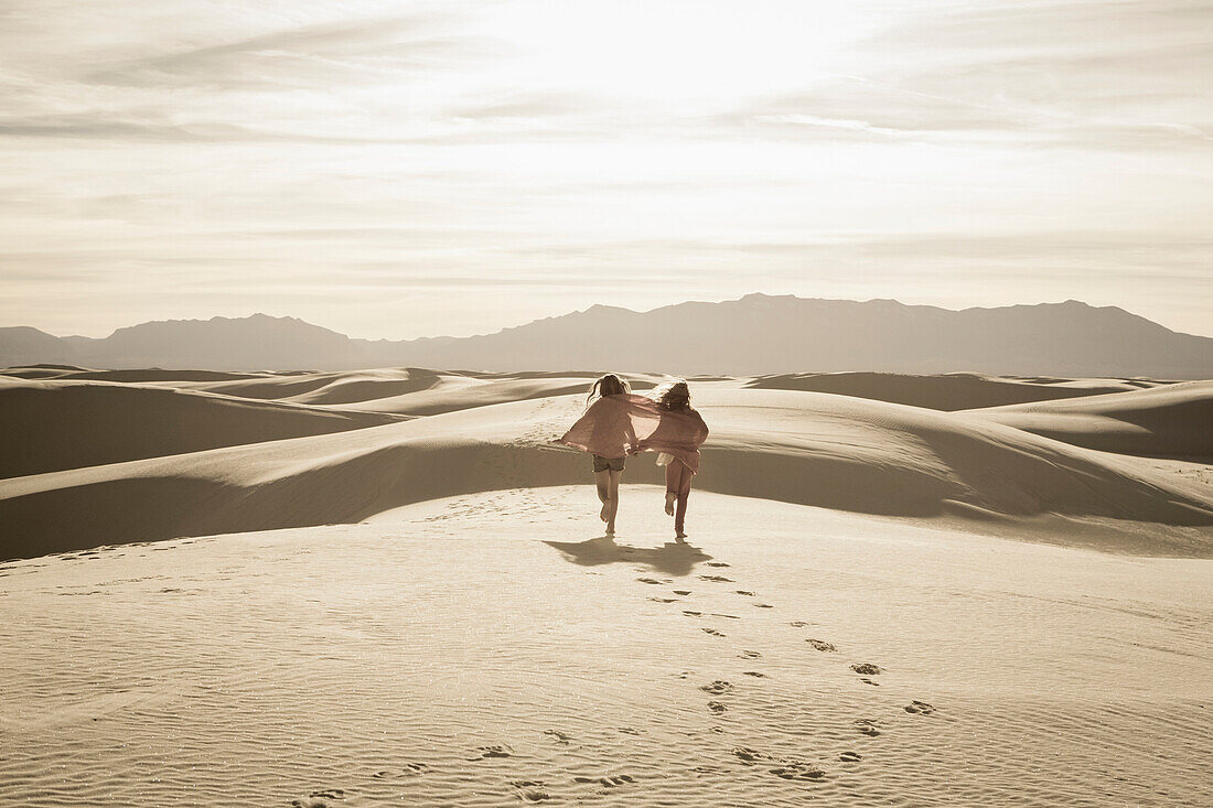 Caucasian children running in desert