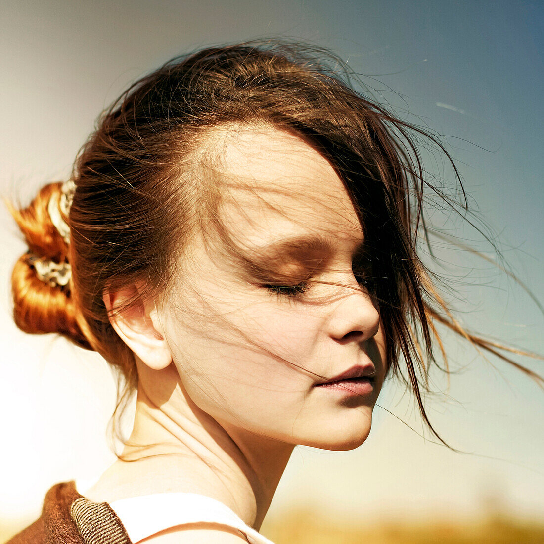 Caucasian teenage girl with eyes closed outdoors