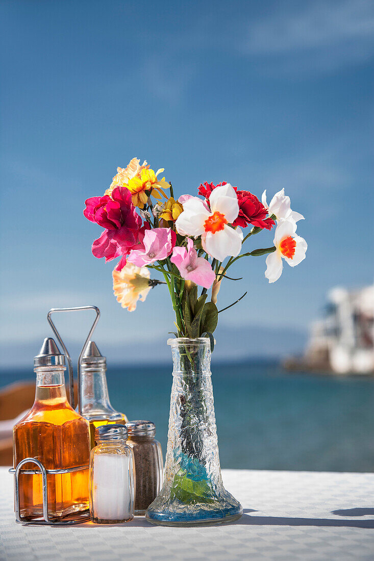 Seasonings and flowers on oceanfront cafe table