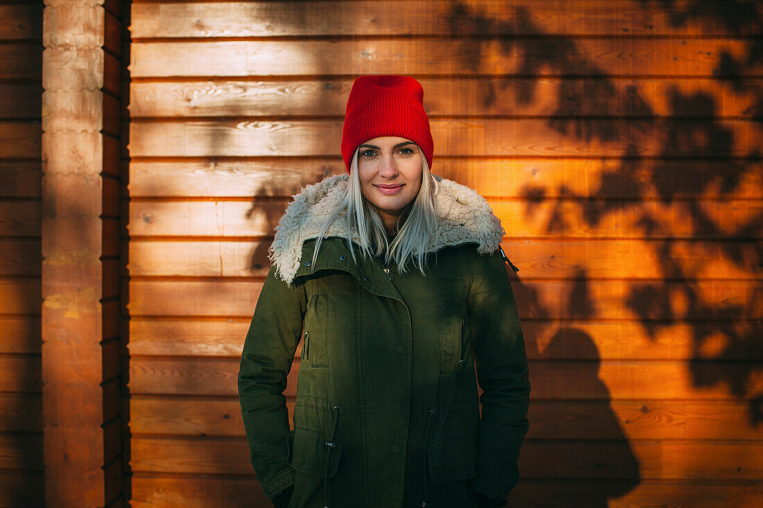 Portrait of confident beautiful woman standing against wall