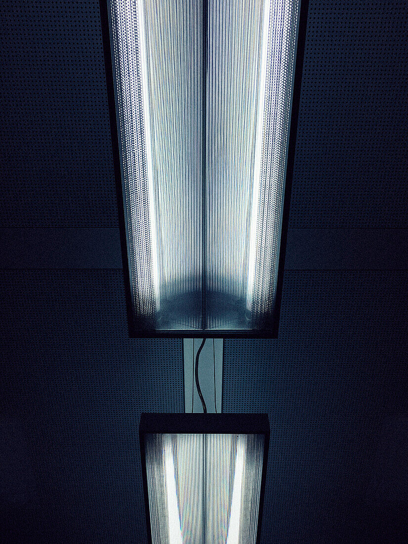 Low angle view of illuminated fluorescent lights on ceiling