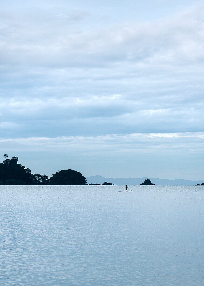 Stand up paddler after sunset in Buffalo Bay Ao Khao Kwai, Ko Phayam, Andaman coast, Thailand, Southeast Asia