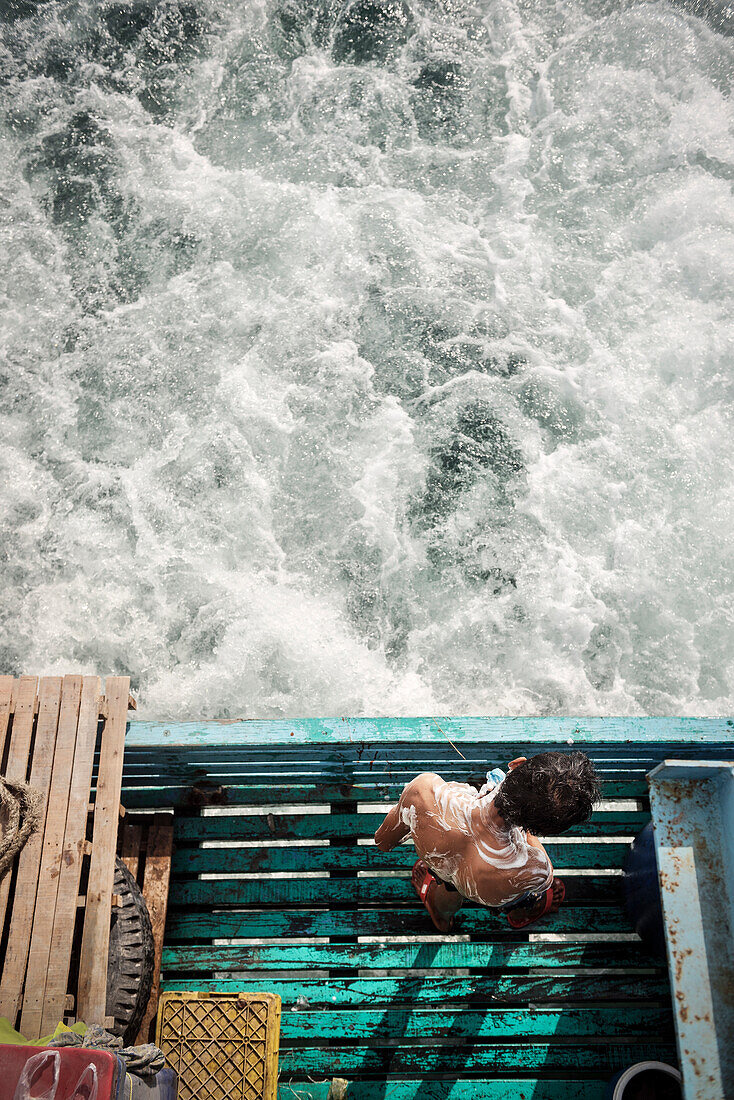 Seemann wäscht sich am Heck des Schiffes, Ko Phayam, Andamanensee, Thailand, Südost Asien