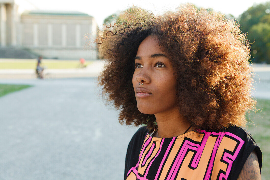 Junge afroamerikanische Frau im Gegenlicht in der Stadt, Königsplatz, München, Bayern, Deutschland