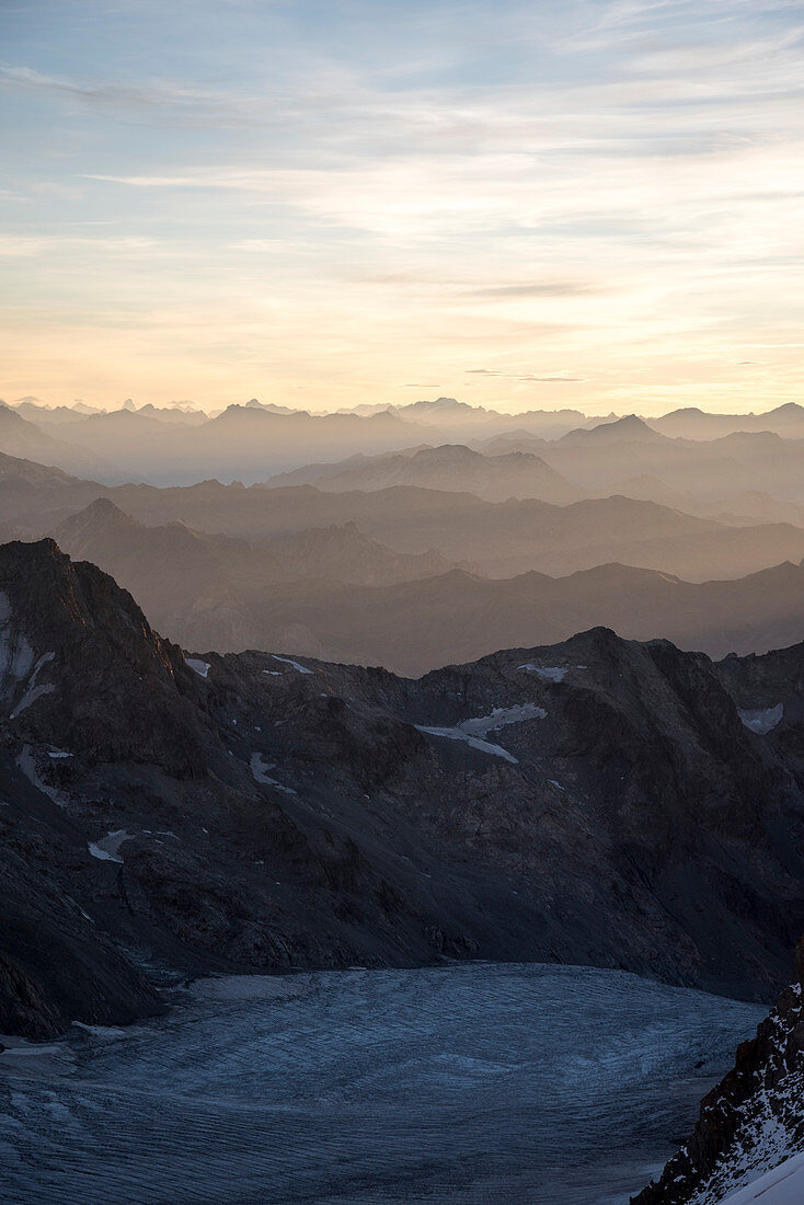 Morning dawn ascending the Barre des Ecrins with views of the Western Alps as far as the Matterhorn, Ecrins National Park, Dauphiné, France