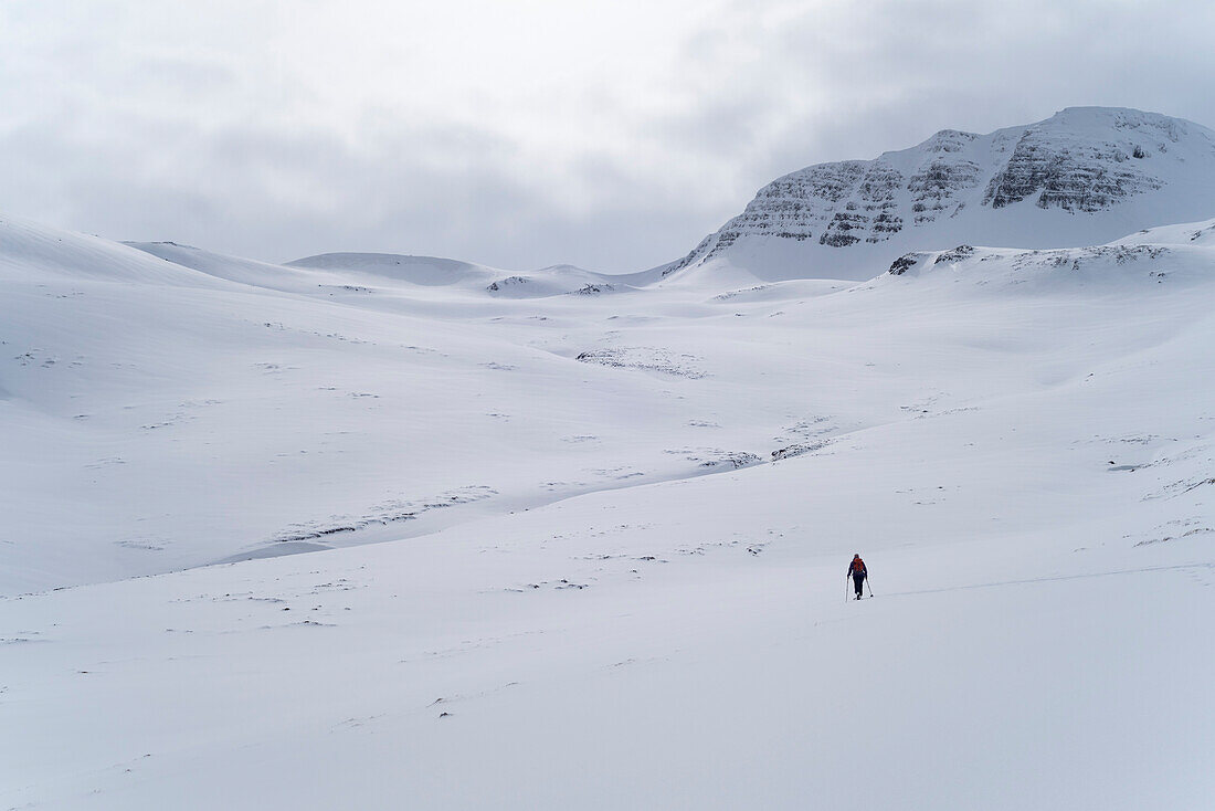 A female skitourer in the valley named Mánárdalur near Siglufjörður, Tröllaskagi or in English Troll Peninsula, Iceland