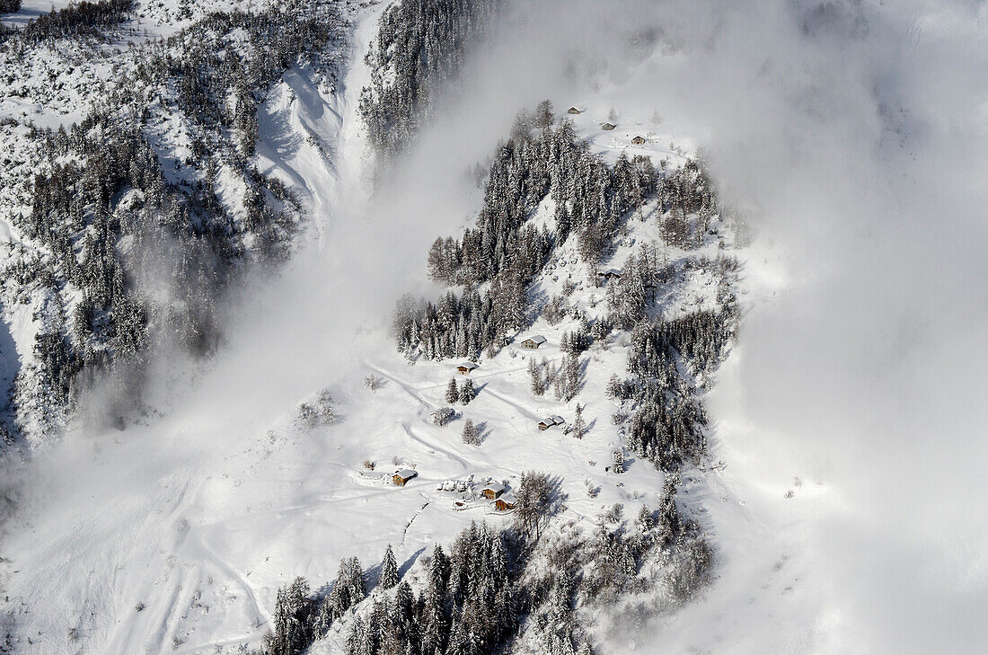 Eine künstlich ausgelöste Katastrophenlawine donnert in der Nähe von unbewohnten Häusern über das Testgelände des Schweizer WSL-Instituts für Schnee- und Lawinenforschung (SLF) im Vallée de la Sionne, westliche Berner Alpen, Kanton Wallis, Schweiz
