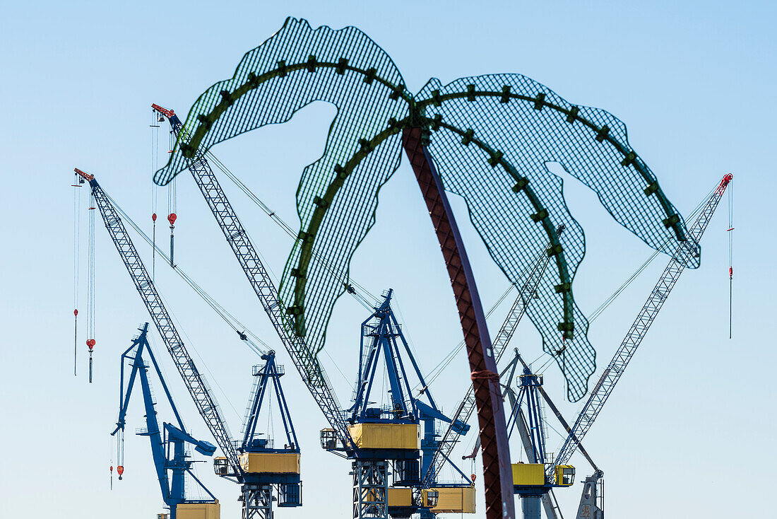 Eine Metallpalme in der Anlage Park Fiction an der Grenze Altona Altstadt zu St. Pauli mit Blick auf Kräne der Werft Blohm und Voss, Hamburg, Deutschland