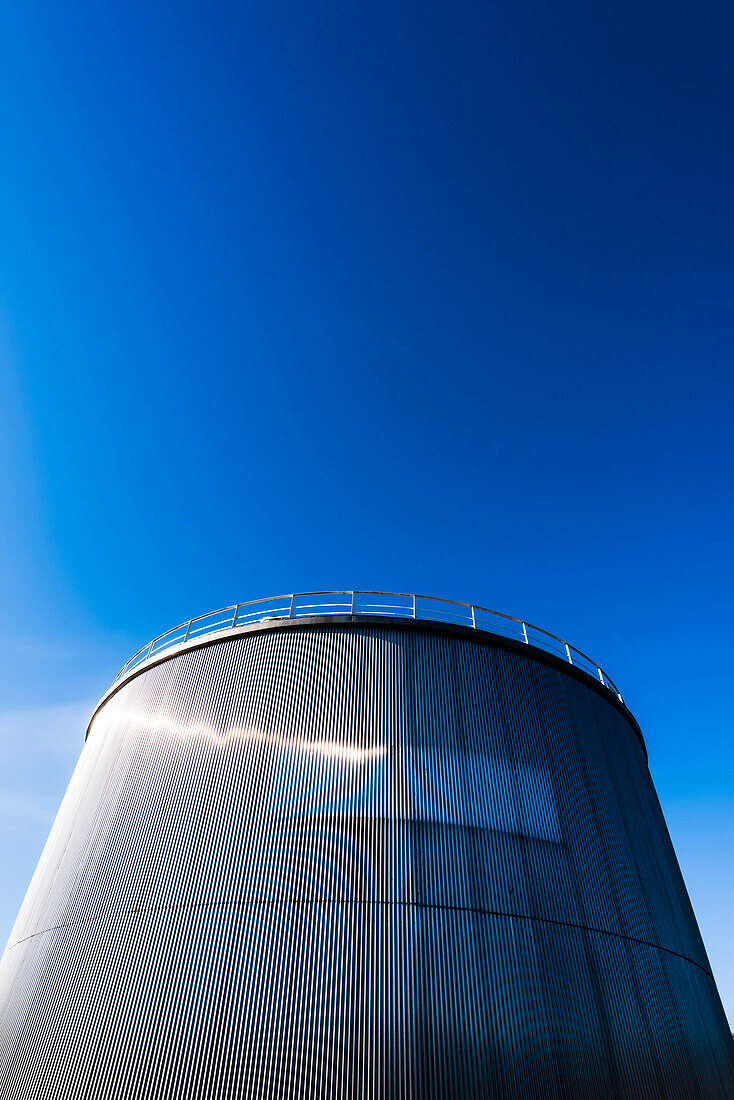 Ein großer silbriger Tank einer Industrieanlage vor blauem Himmel, Hamburg, Deutschland