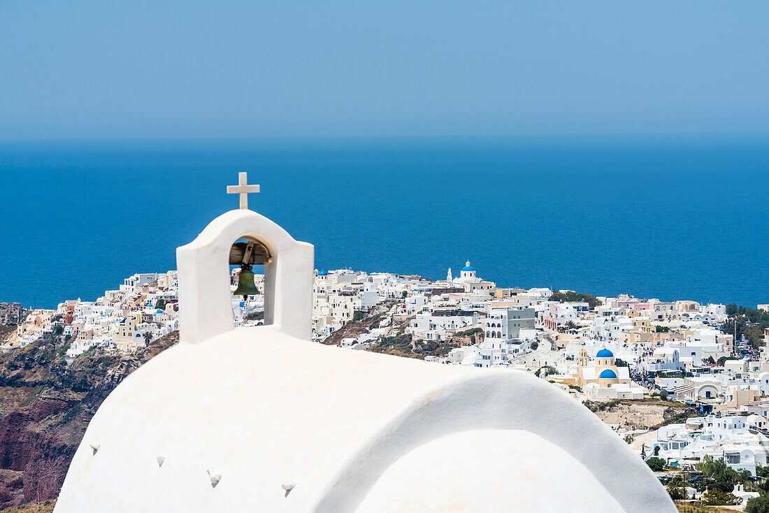 Der Glockenturm einer Griechisch Orthodoxen Kapelle mit Blick auf den Ort Oia und das Mittelmeer bis zum Horizont, Oia Santorin, Kykladen, Griechenland
