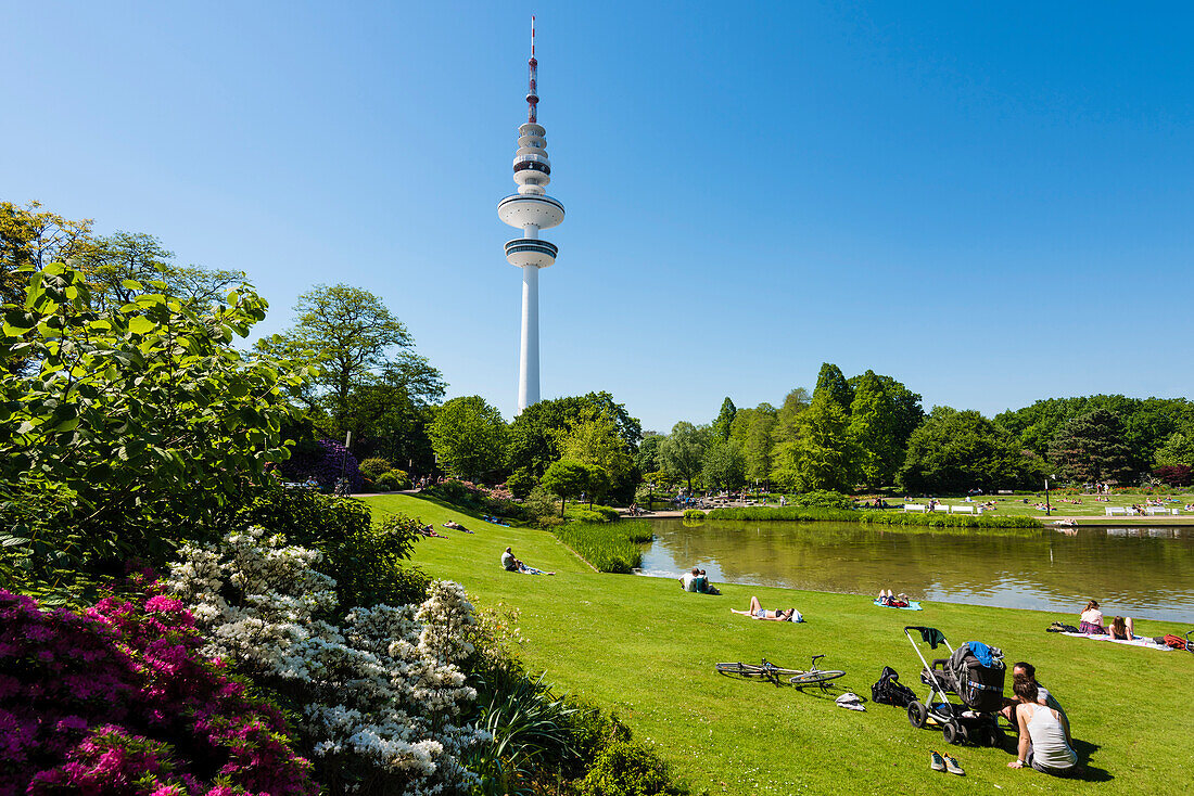 'Besucher erholen sich im Naherholungsgebiet ''Planten un Blomen'' in der Innenstadt  mit Blick auf den Fernsehturm, Hamburg, Deutschland '