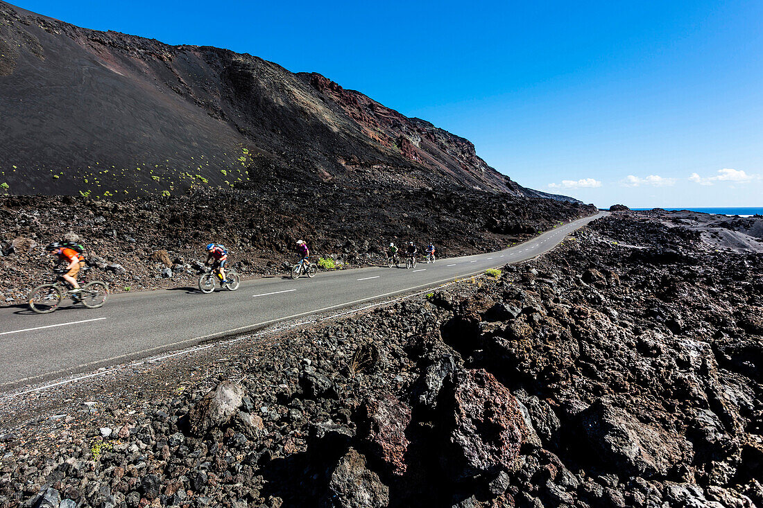 Radfahrer auf einer Straße an der Südspitze im Vulkangebiet, El Charco, La Palma, Kanarische Inseln, Spanien