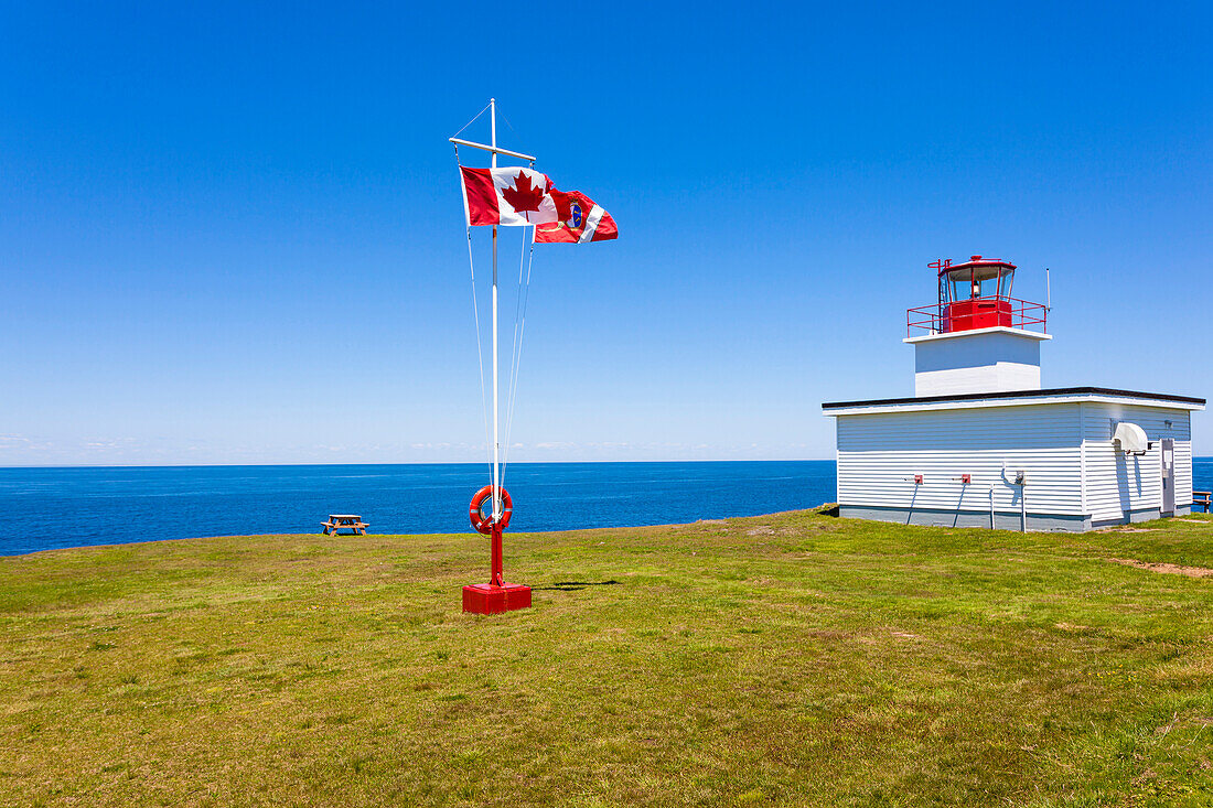 Ein ruhiger Platz mit Bank, kanadischer Nationalflagge und Leuchturm am Nordatlantischen Ozean, Digby, Nova Scotia, Kanada