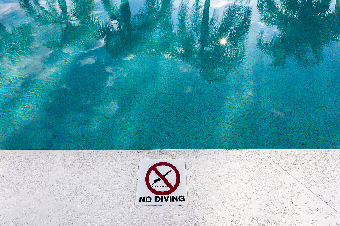 Pool, No Diving sign, water reflection with palm trees, Naples, Florida, USA