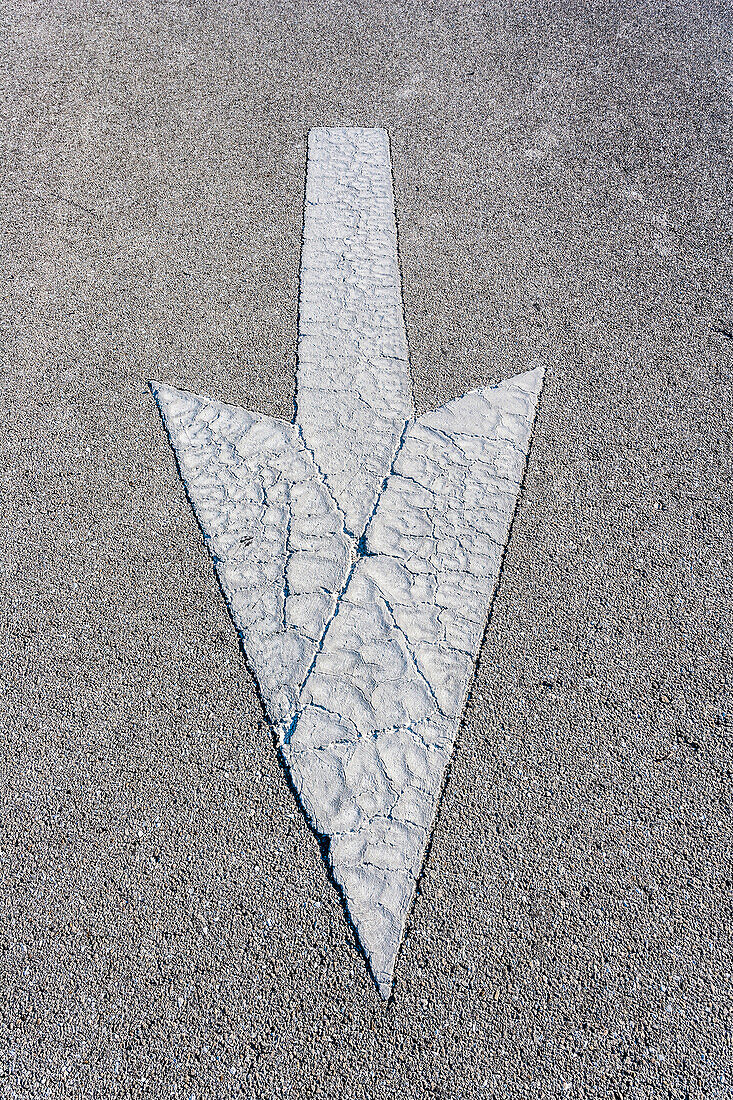 White worn arrow on an asphalted street, Naples, Florida, USA