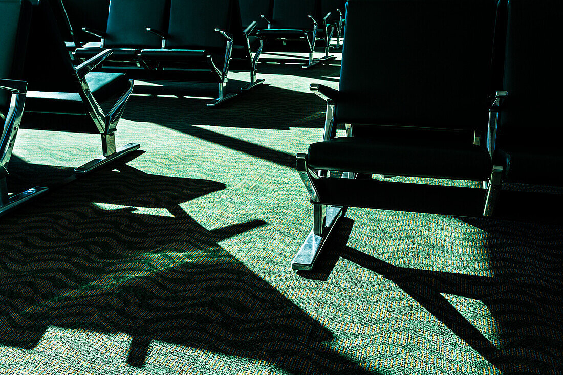 Warteraum in einem Flughafen mit grünem Teppich und schwarzen Stühlen, Ft.Myers, Florida, USA