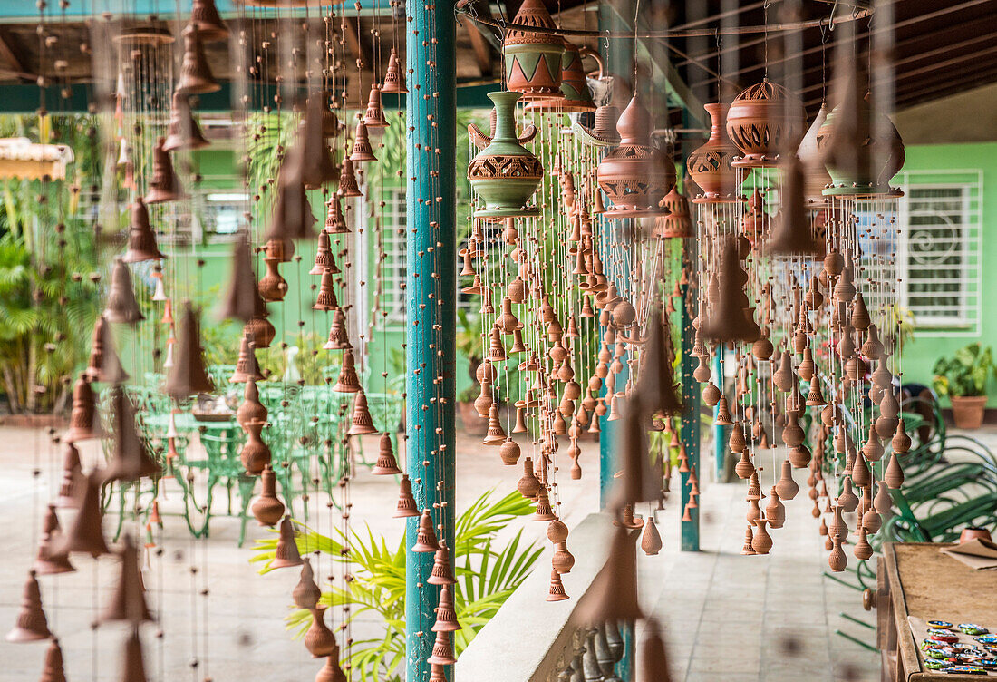 'Spiral clay wind chimes on display in the studio of Daniel Chichi'' Santander, renowned Cuban potter.  The Santander Family Shop can be seen in the background in Trinidad, Sancti Spiritus, Cuba.'''