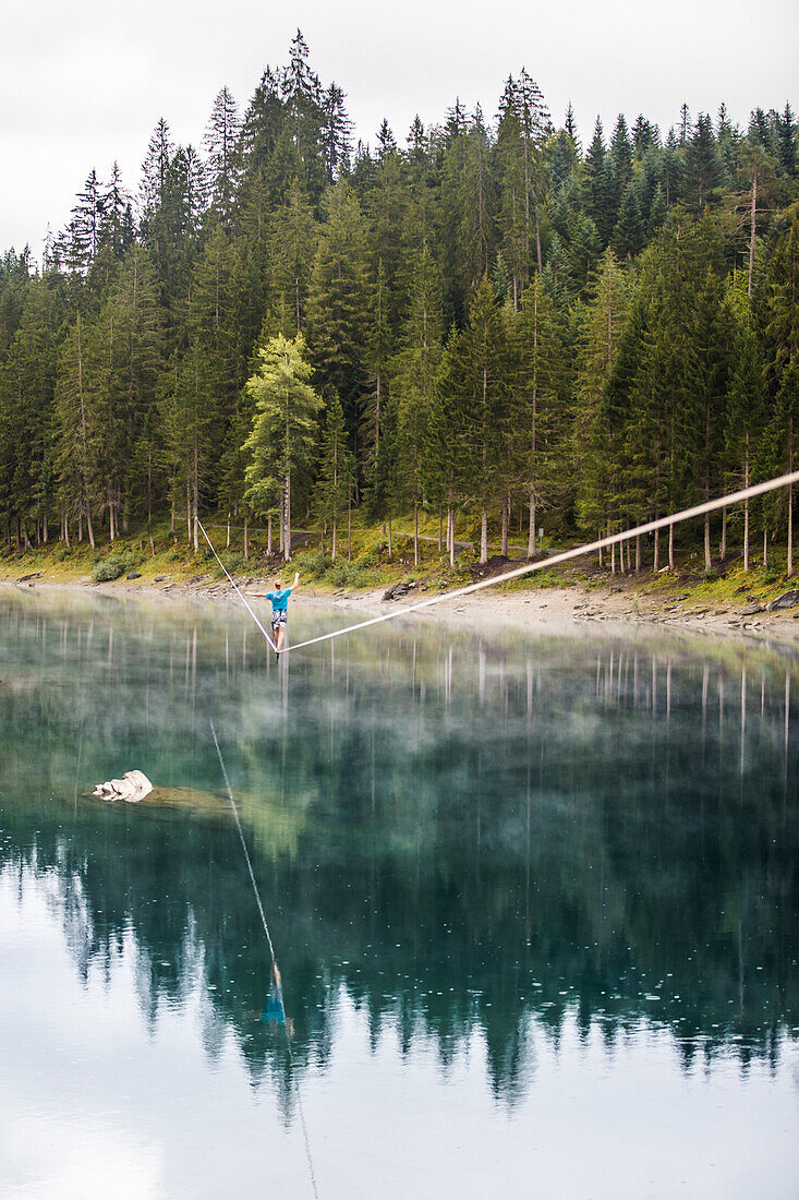 Slackliner on a waterline in Switzerland at lake Cauma.