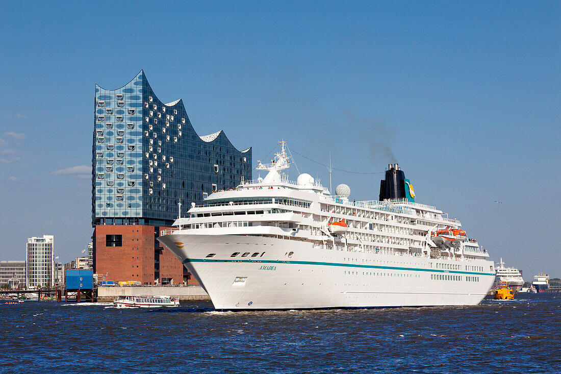 Cruise liner Amadea leaving at the harbour, view to the Elbphilharmonie, Hamburg, Germany