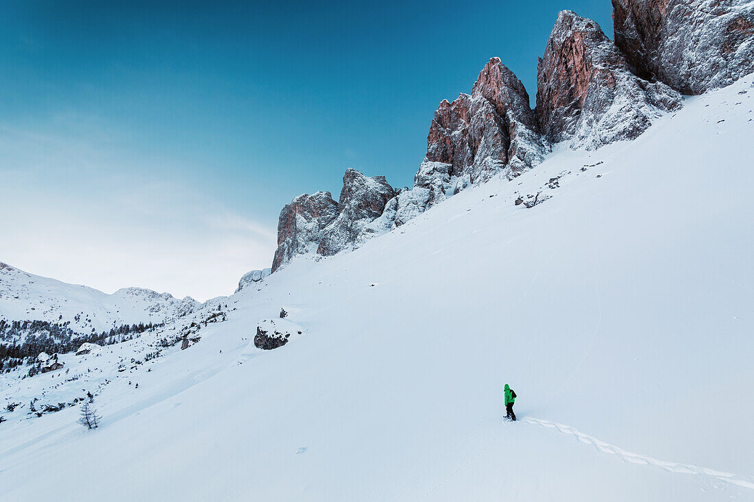 Snowshoe hiker beneath the Villnoesser Geisler, Gruppo delle Odle, Dolomites, Unesco world heritage, Italy