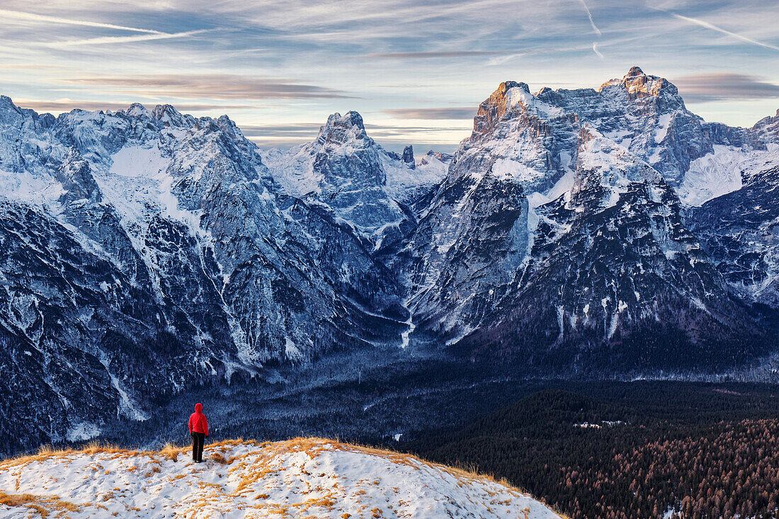 Wanderer genießt Bergpanorama am frühen Morgen Richtung Belluneser Dolomiten, Unesco Weltkulturerbe, Italien
