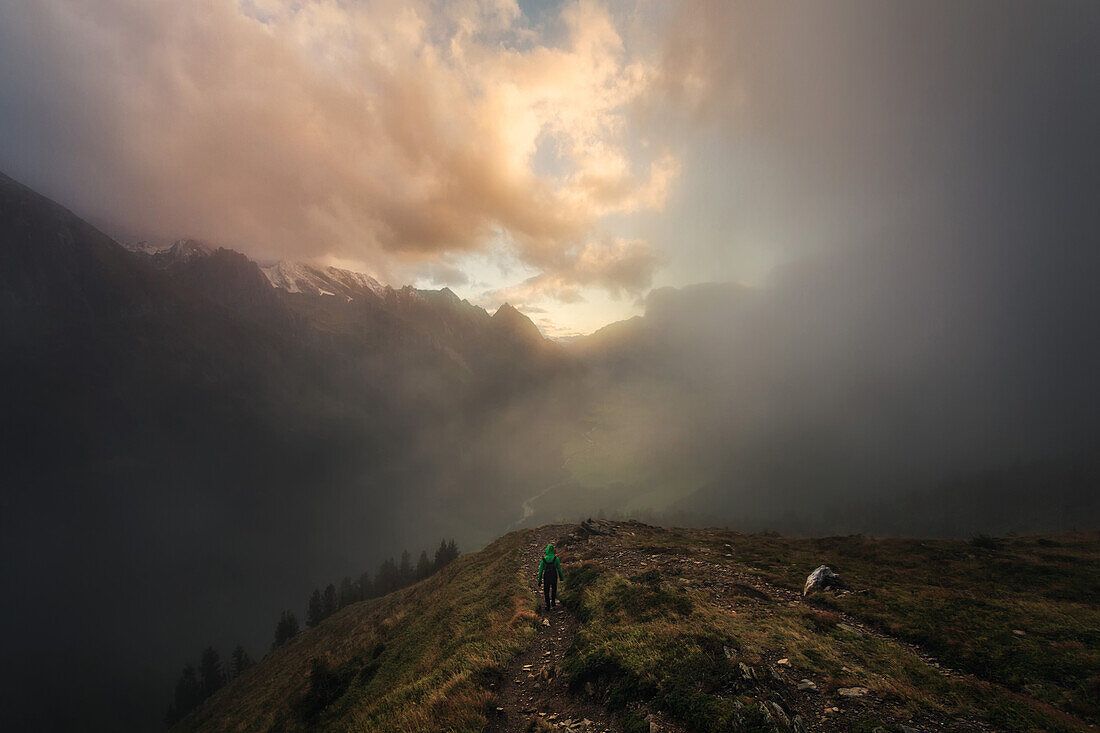 Hiker on his way back from Pfitscherjoch mountain pass, in the background Pfitsch Valley, South Tyrol, Italy