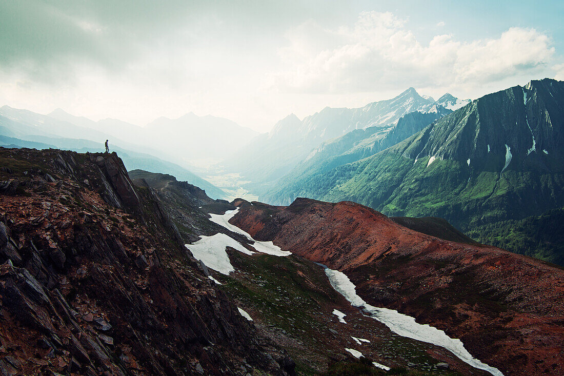 Wanderer genießt Ausblick oberhalb des Pfitscherjochs, im Hintergrund das Pfitsch Tal in Südtirol, Italien