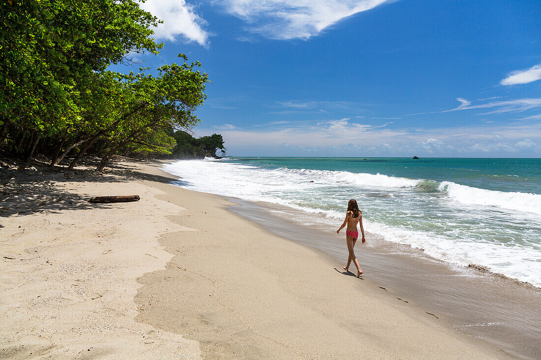 Girl walking along sandy beach, Tobago, West Indies, South America