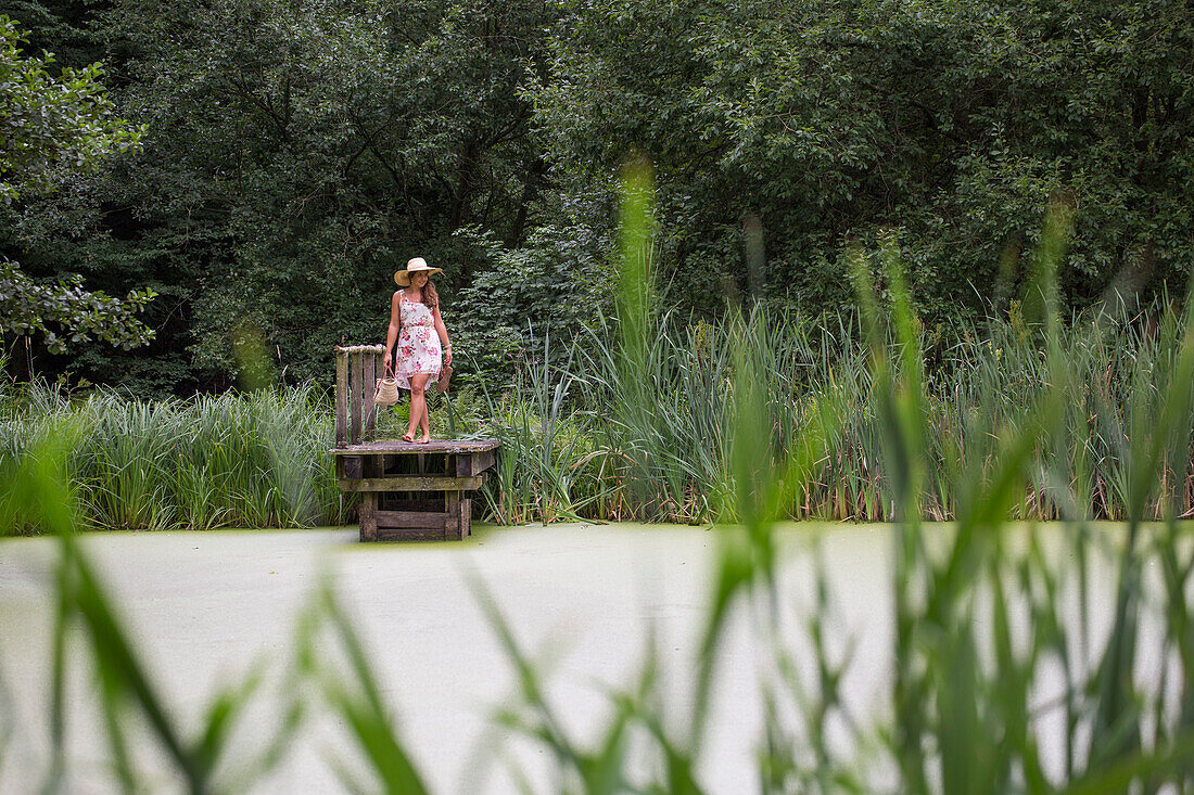 Junge Frau im Sommerkleid auf Steg am Teich, Haunetal, Rhön, Hessen, Deutschland [MR]
