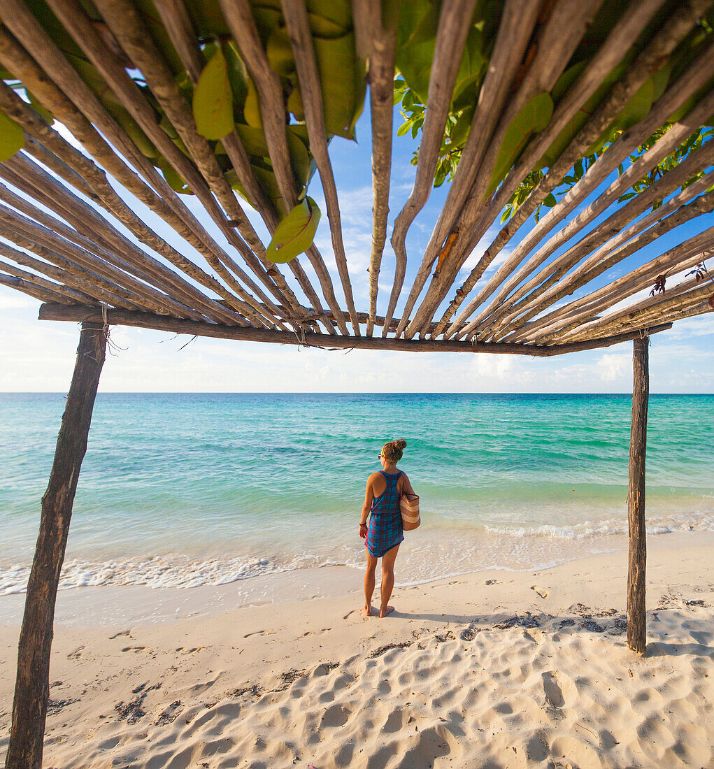 A young woman  carries a beach bag at the beach in Cayo Coco, Cuba.